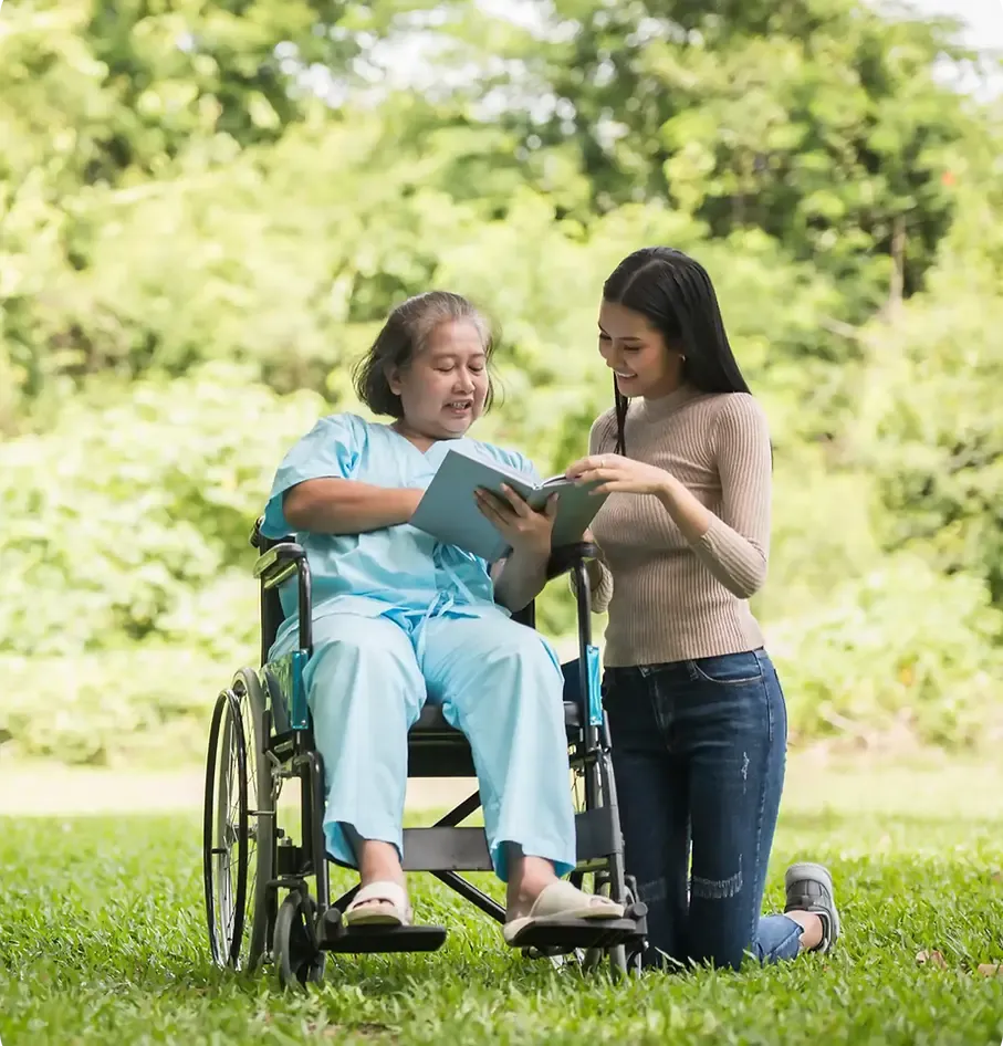 Caregiver reading with an elderly client outdoors